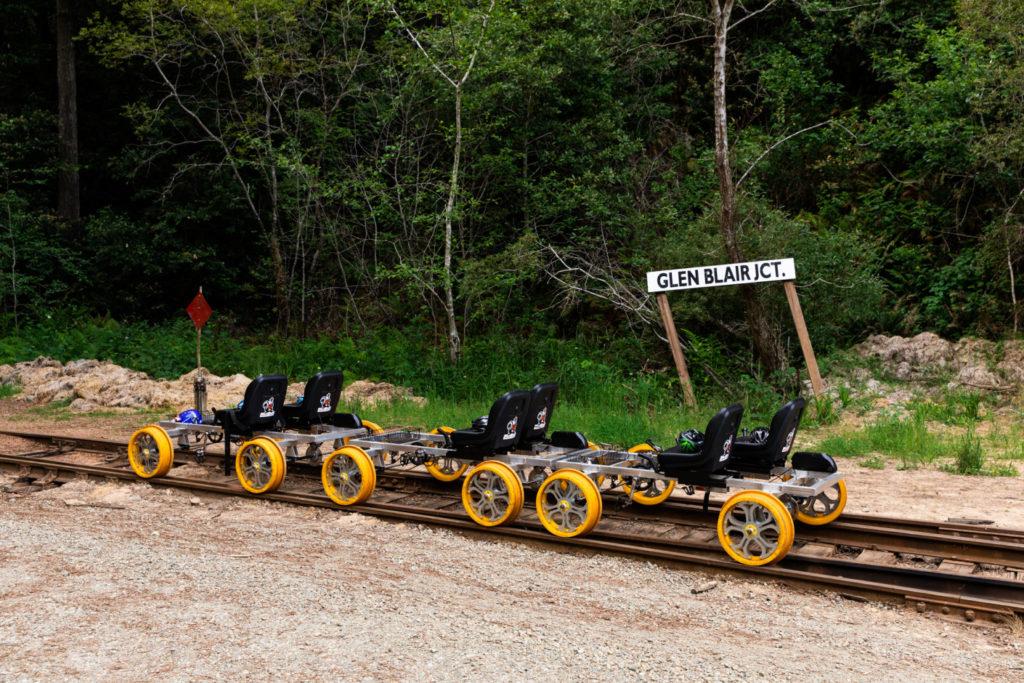 Empty railbikes sitting on track by Glen Blair Jct sign