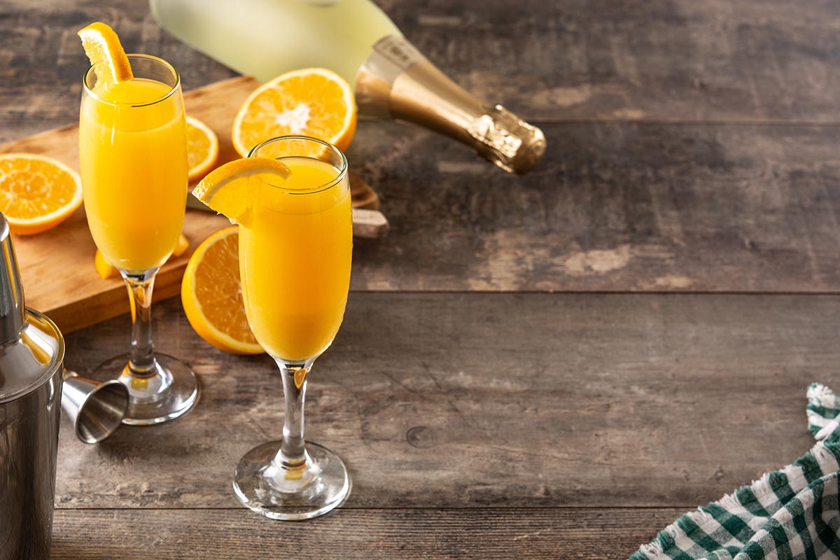 Orange mimosa cocktail on wooden table